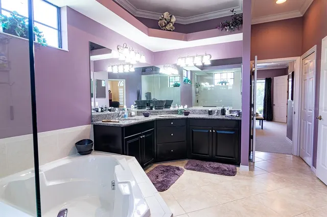 a bedroom with a bed and a lamp on dresser