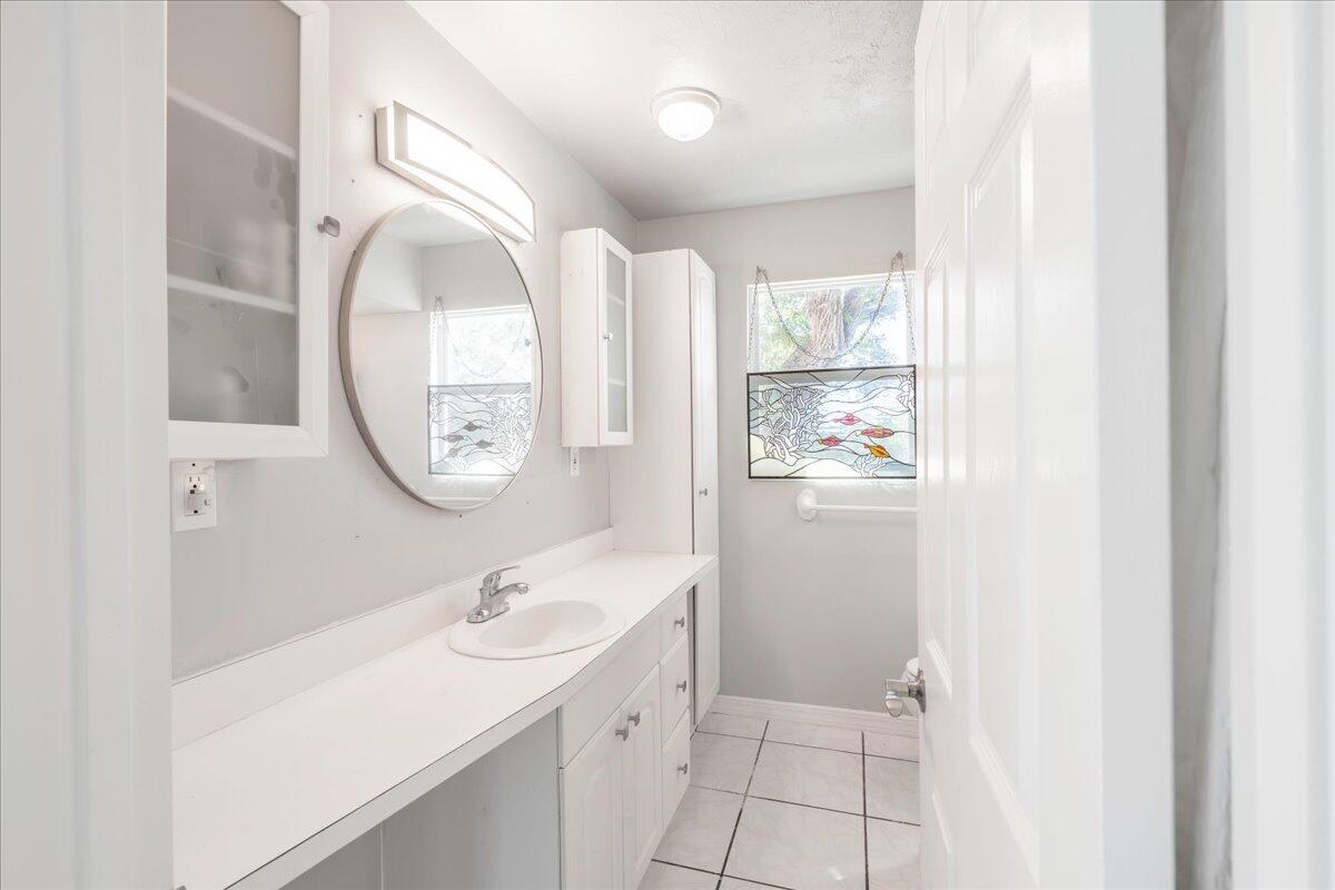3167 Stewart Road Summerland Key, FL 33042 - Photo 17 of 33 a bathroom with a granite countertop sink a mirror and a shower