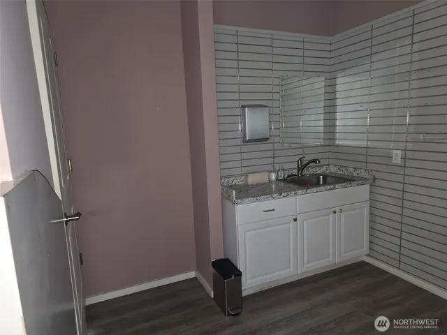 a bathroom with a granite countertop sink toilet and vanity
