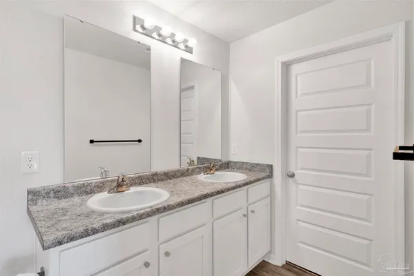 a bathroom with a granite countertop sink a mirror and a shower