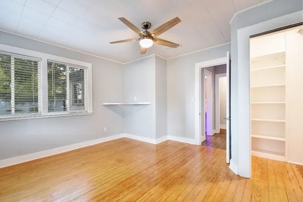 a view of a livingroom with wooden floor and a ceiling fan