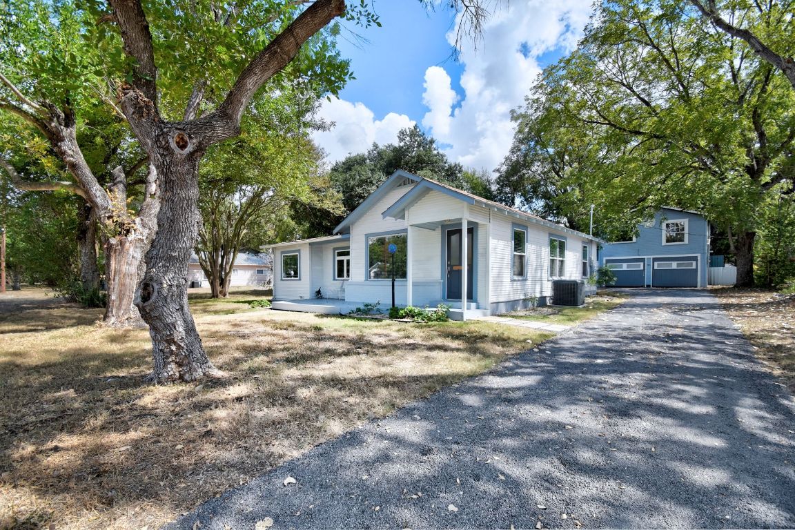 717 South Laurel Avenue Luling, TX 78648 - Photo 2 of 34 a front view of a house with a garden and trees