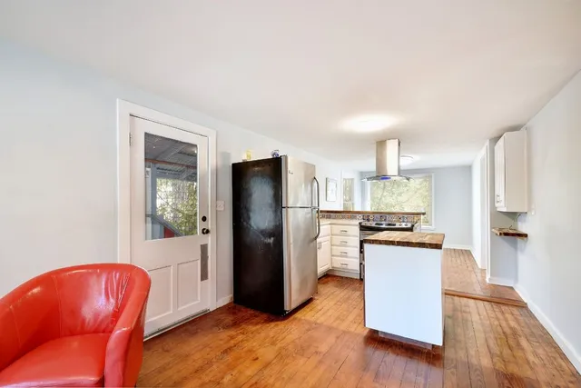 a kitchen with stainless steel appliances a refrigerator and wooden floor