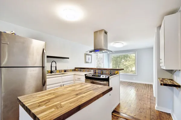 a kitchen with kitchen island a stove a sink and a refrigerator