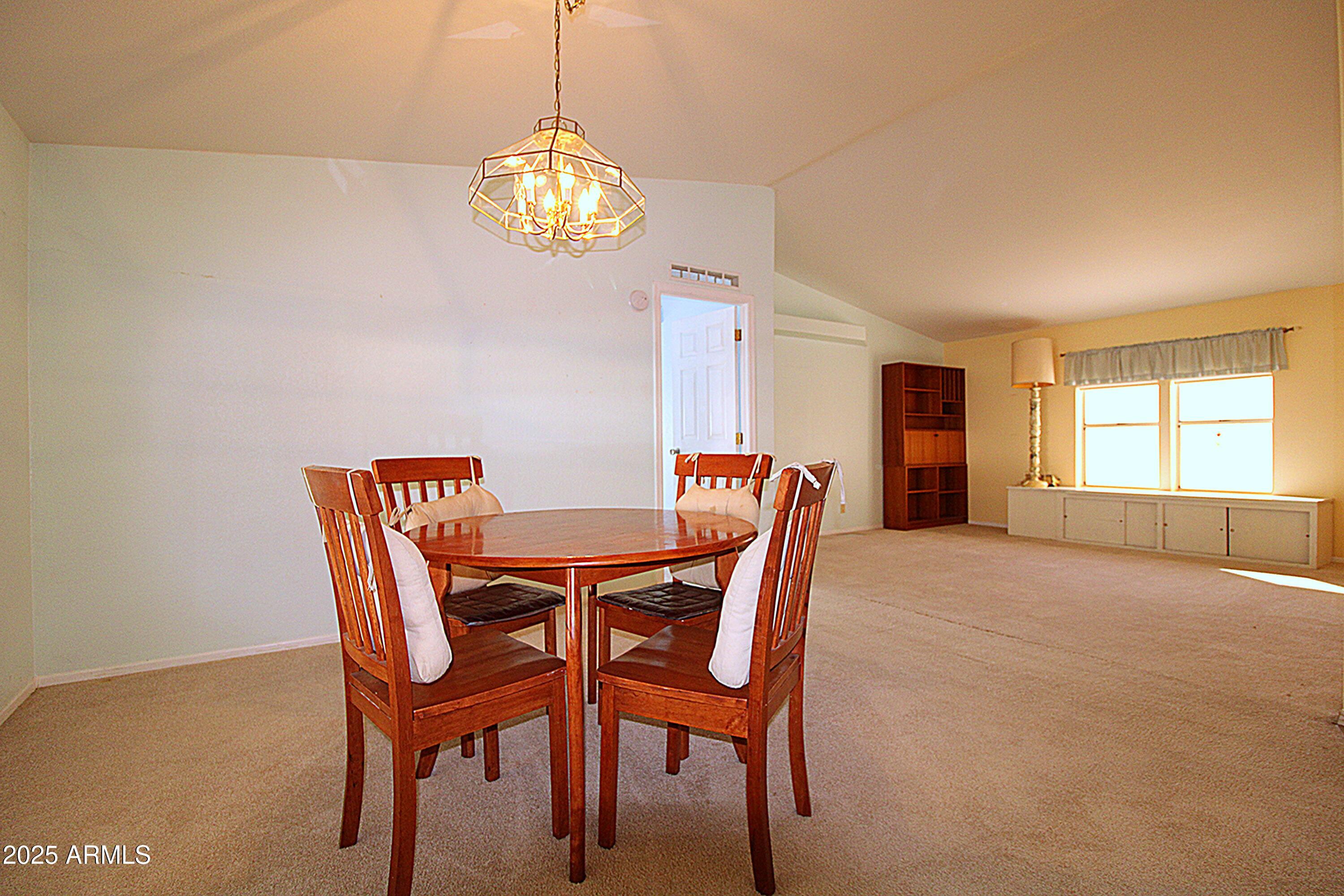 2400 East Baseline Avenue, Unit 232 Apache Junction, AZ 85119 - Photo 15 of 37 a view of a dining room with furniture and chandelier