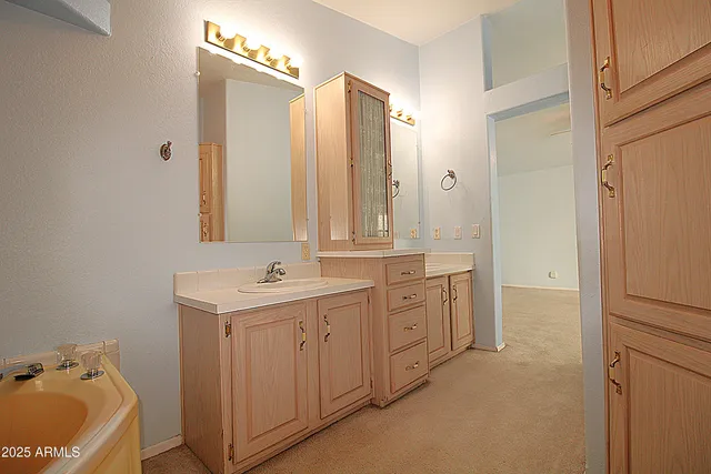 a bathroom with a tub sink and mirror