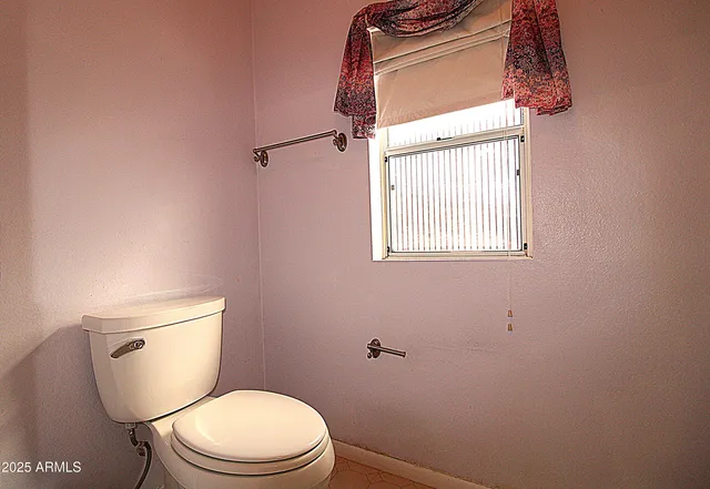 a white toilet sitting next to a window