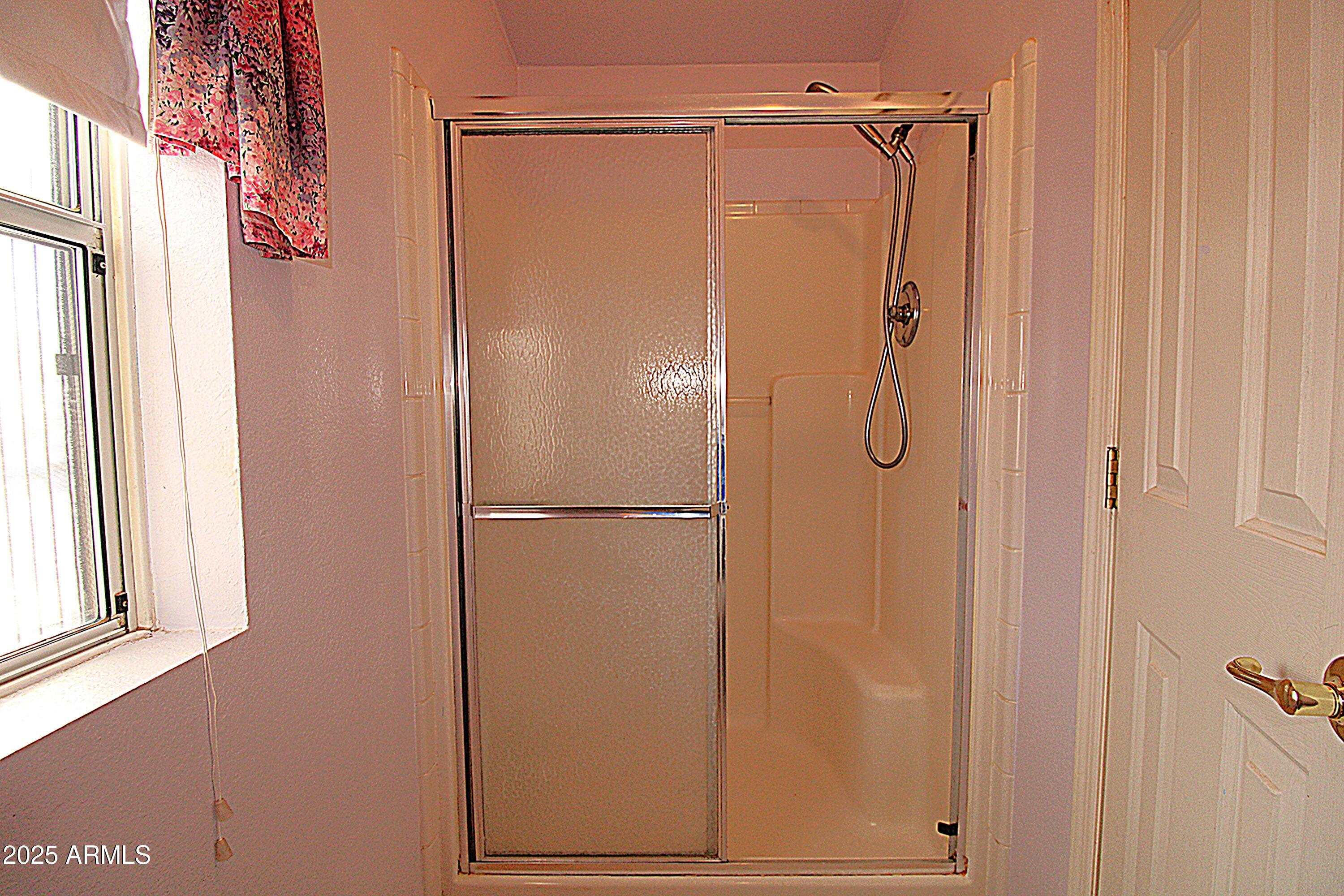 2400 East Baseline Avenue, Unit 232 Apache Junction, AZ 85119 - Photo 23 of 37 a bathroom with a glass shower door