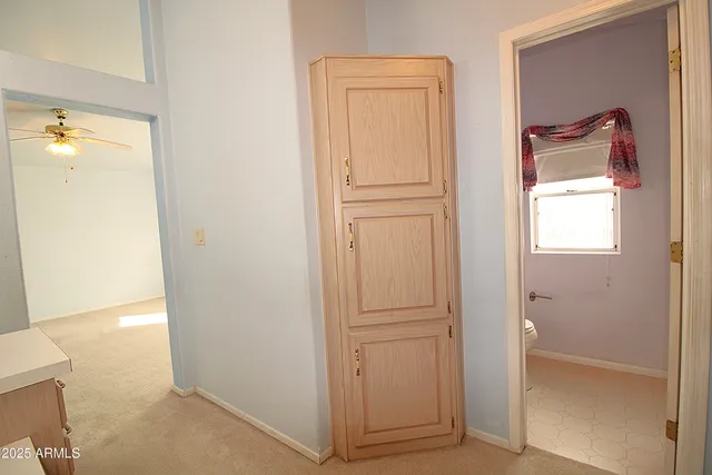 a view of a hallway with closet and a bathroom
