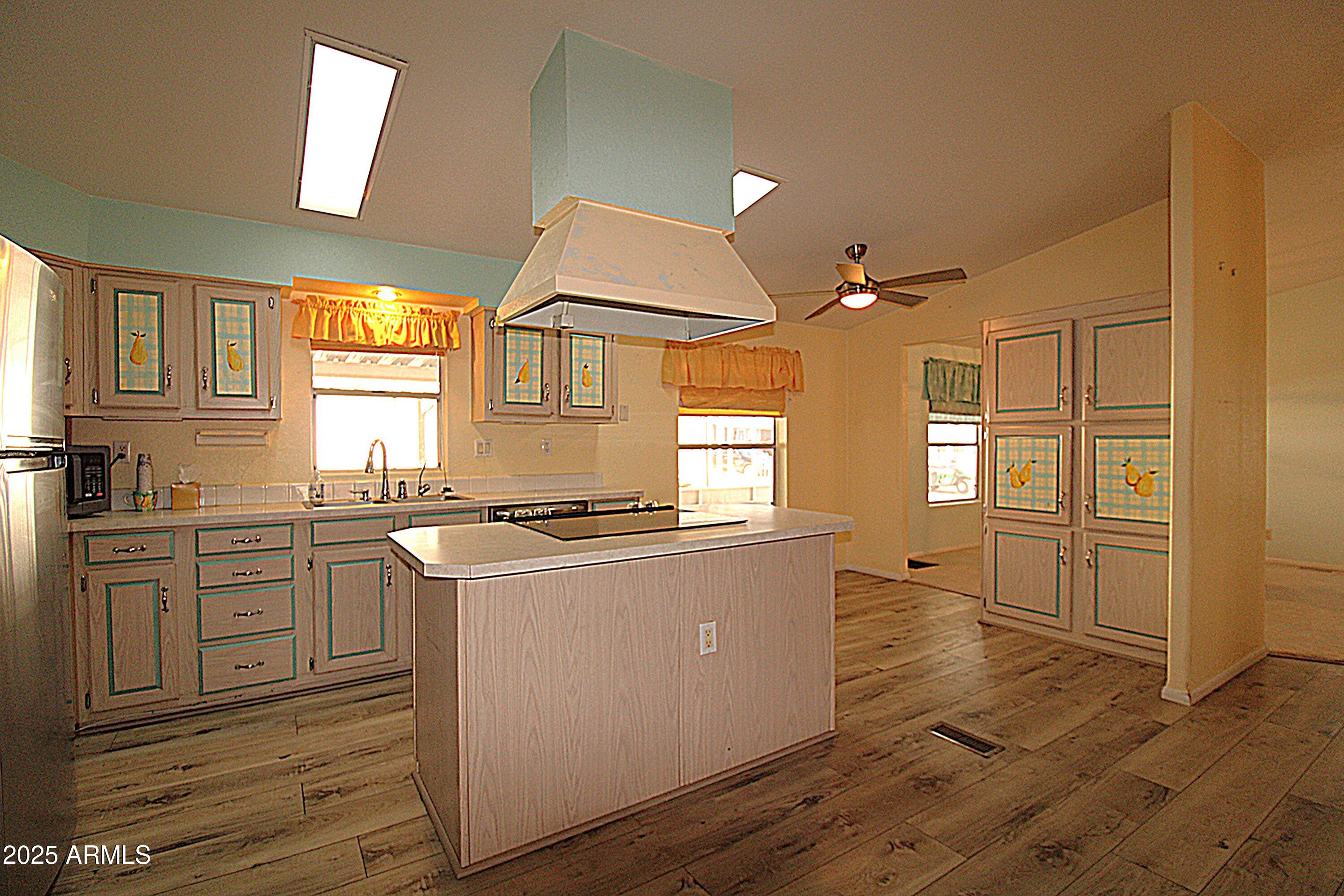 2400 East Baseline Avenue, Unit 232 Apache Junction, AZ 85119 - Photo 8 of 37 a kitchen with cabinets wooden floor and a stove top oven