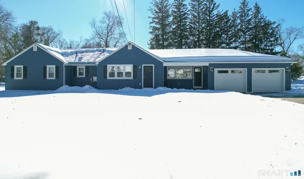 a front view of a house with a yard covered in snow