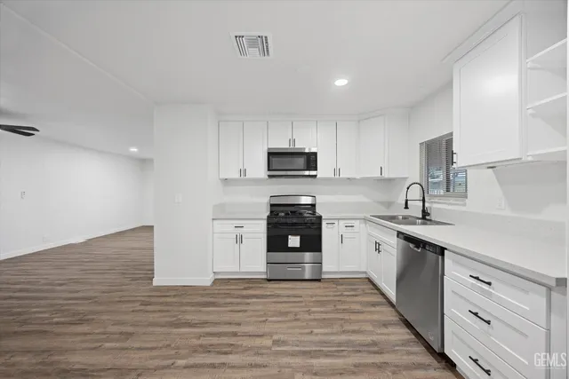 a view of a kitchen with a sink and wooden floor