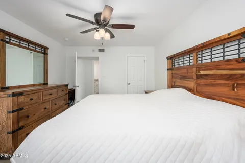 a bedroom with a bed and a flat tv screen on dresser