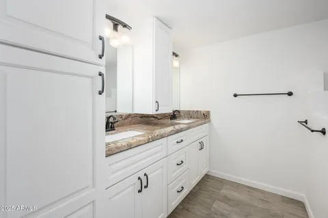 a bathroom with a granite countertop sink and a mirror