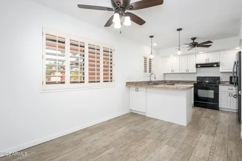 a kitchen with a refrigerator and white cabinets