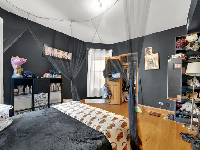 a bedroom with bed and a flat tv screen on the dresser