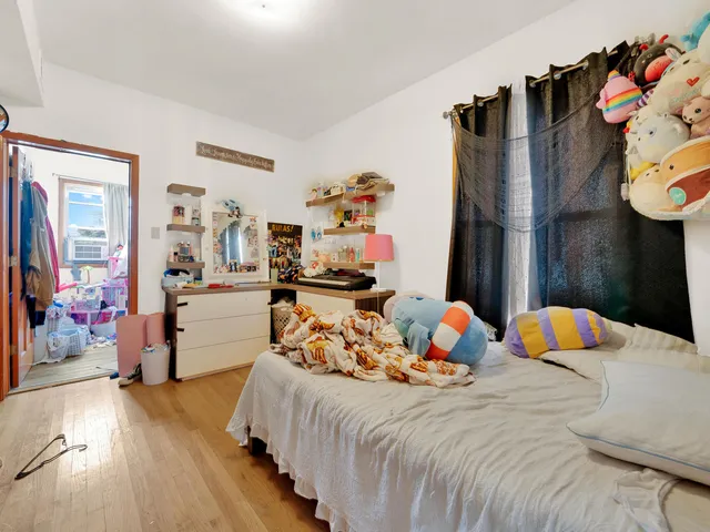 a bedroom with bed and wooden floor
