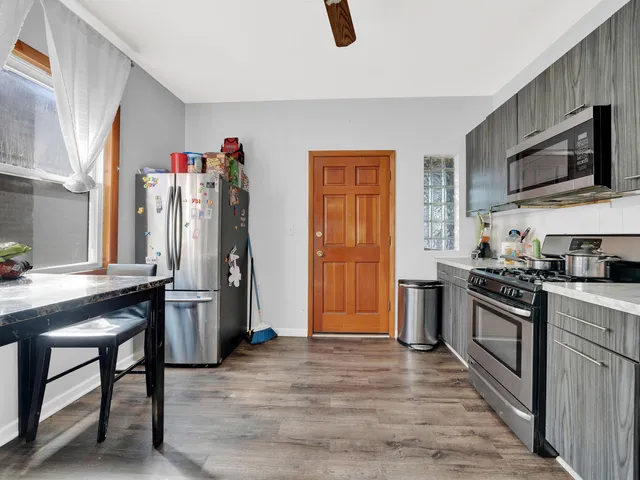 a kitchen with stainless steel appliances granite countertop a refrigerator and a stove top oven