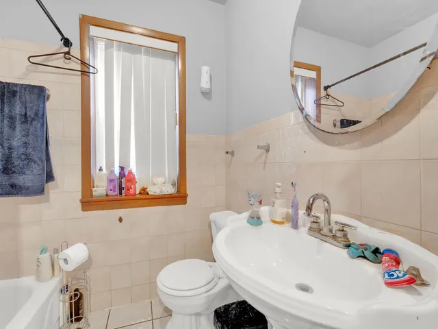 a bathroom with a sink a toilet and a mirror