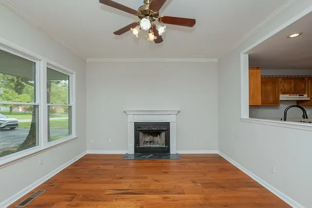 a view of an empty room with window and fire place