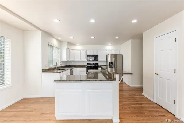 a large kitchen with kitchen island a sink stainless steel appliances and cabinets
