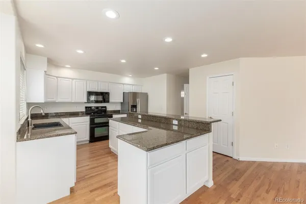 a kitchen with stainless steel appliances granite countertop a sink and a stove