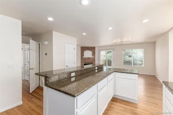 a large kitchen with granite countertop a large counter top space and stainless steel appliances