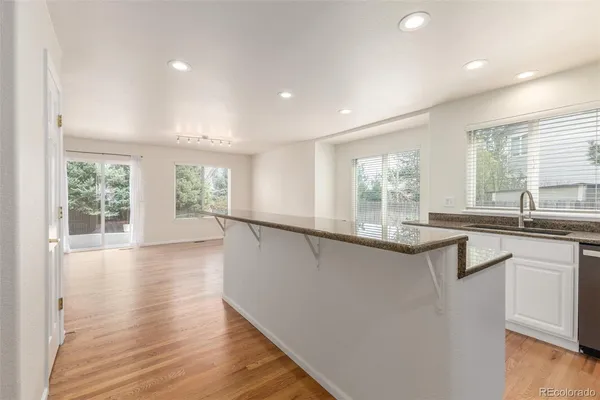 a large kitchen with granite countertop a large window