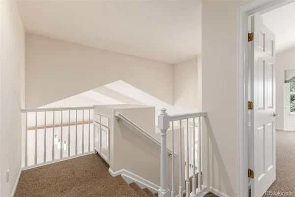 a view of staircase with railing and white walls