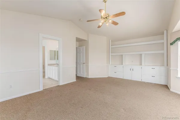 an empty room with chandelier fan and closet