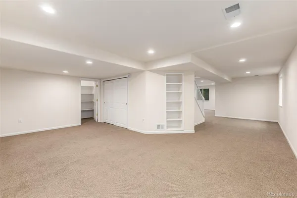 an empty room with a kitchen space and a window
