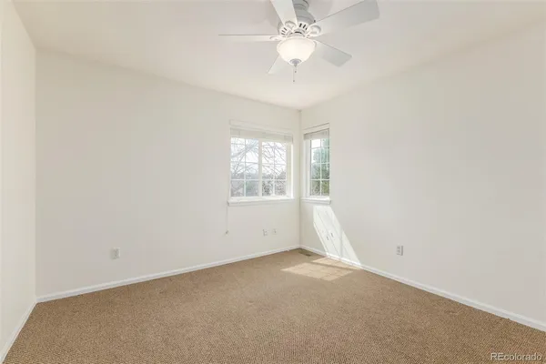 an empty room with a ceiling fan and a window