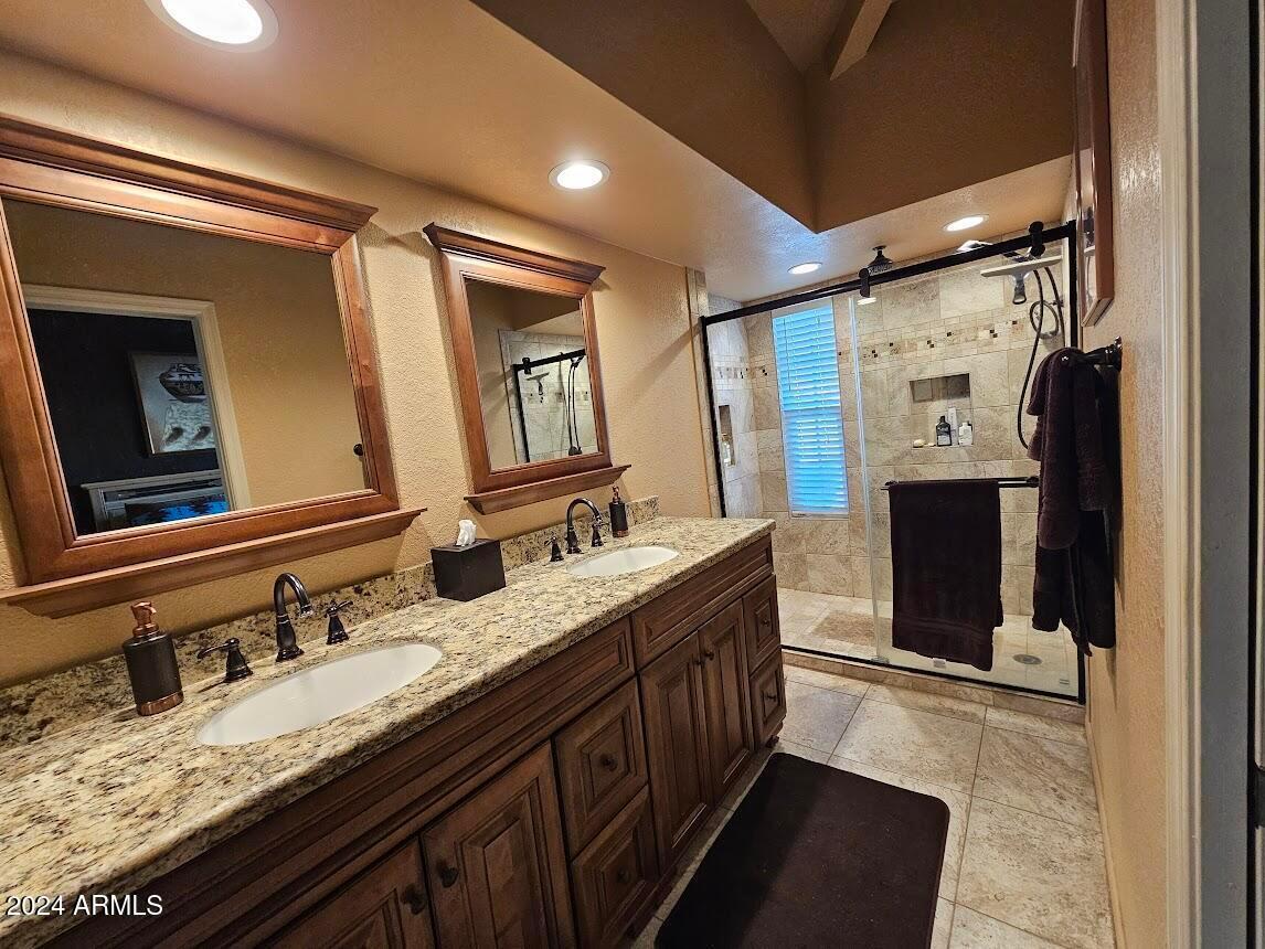 10015 East Mountain View Road, Unit 1002 Scottsdale, AZ 85258 - Photo 16 of 24 a bathroom with a granite countertop double vanity sink and mirror