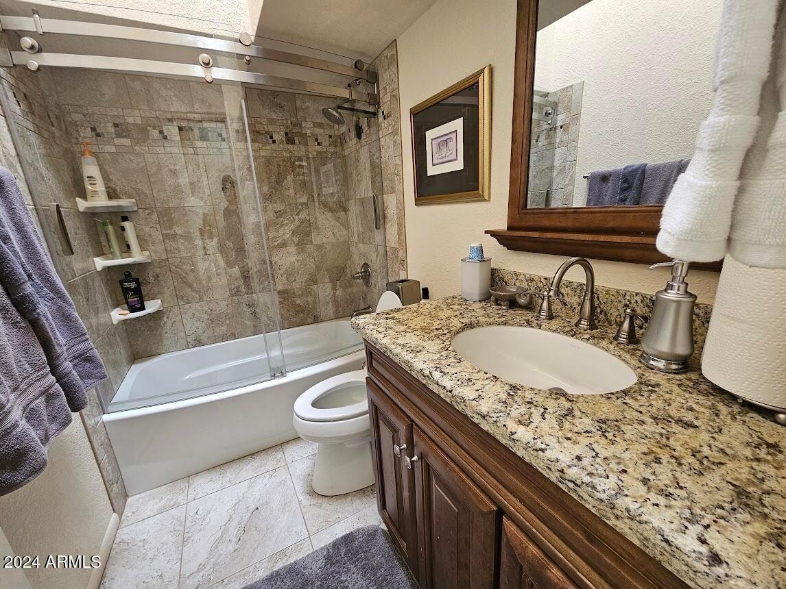 10015 East Mountain View Road, Unit 1002 Scottsdale, AZ 85258 - Photo 19 of 24 a bathroom with a granite countertop sink a toilet and bathtub