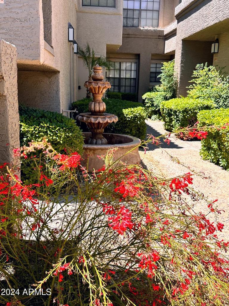 10015 East Mountain View Road, Unit 1002 Scottsdale, AZ 85258 - Photo 21 of 24 a front view of a house with a yard and fountain