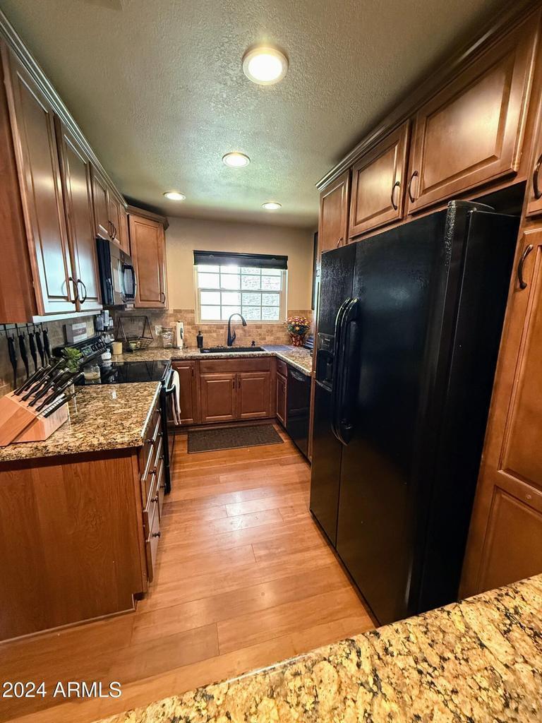 10015 East Mountain View Road, Unit 1002 Scottsdale, AZ 85258 - Photo 9 of 24 a kitchen with stainless steel appliances granite countertop a stove a refrigerator and a sink