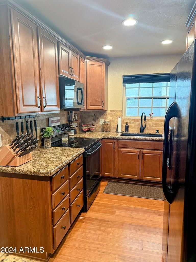 10015 East Mountain View Road, Unit 1002 Scottsdale, AZ 85258 - Photo 10 of 24 a kitchen with stainless steel appliances granite countertop a sink a stove and a refrigerator