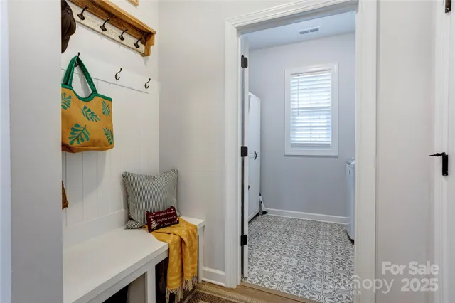 a view of hallway that has painting on the wall and a window