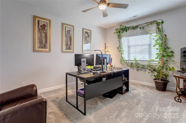 a view of a workspace with furniture and a window