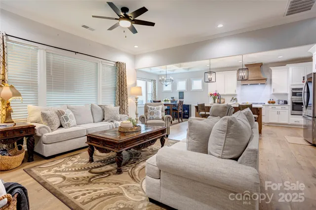 a living room with furniture kitchen view and a window