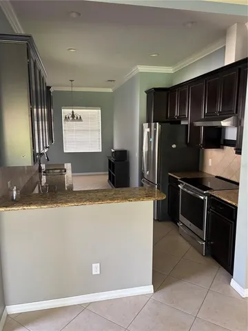 a kitchen with stainless steel appliances granite countertop a refrigerator and a stove