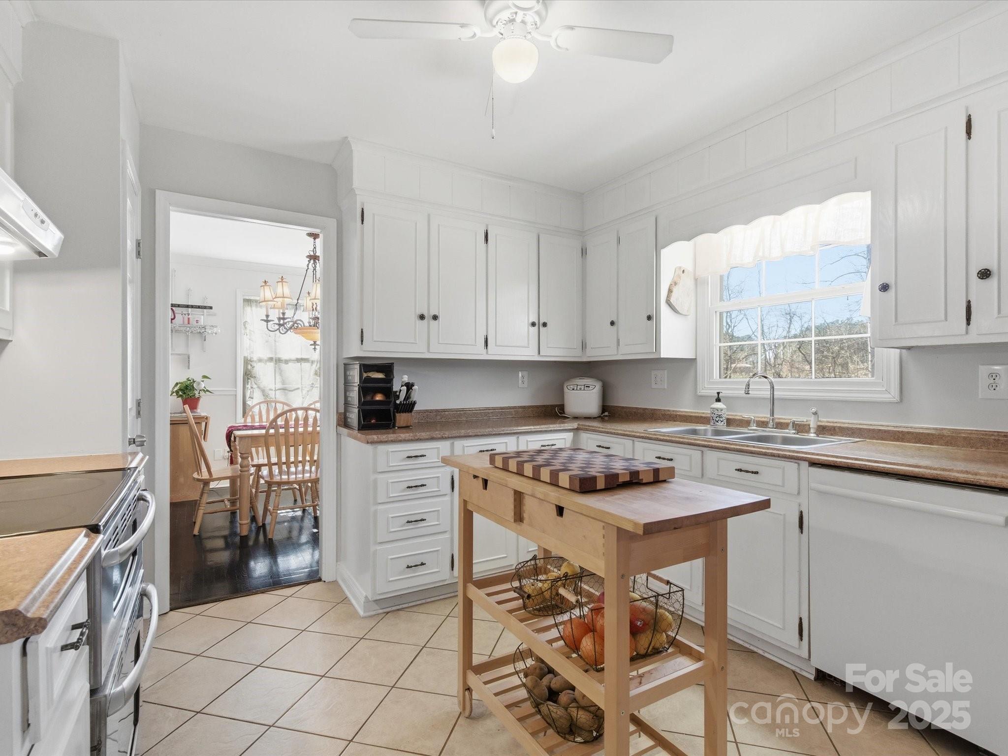 9941 Ferguson Road Charlotte, NC 28227 - Photo 15 of 29 a kitchen with a stove a sink cabinets and a window