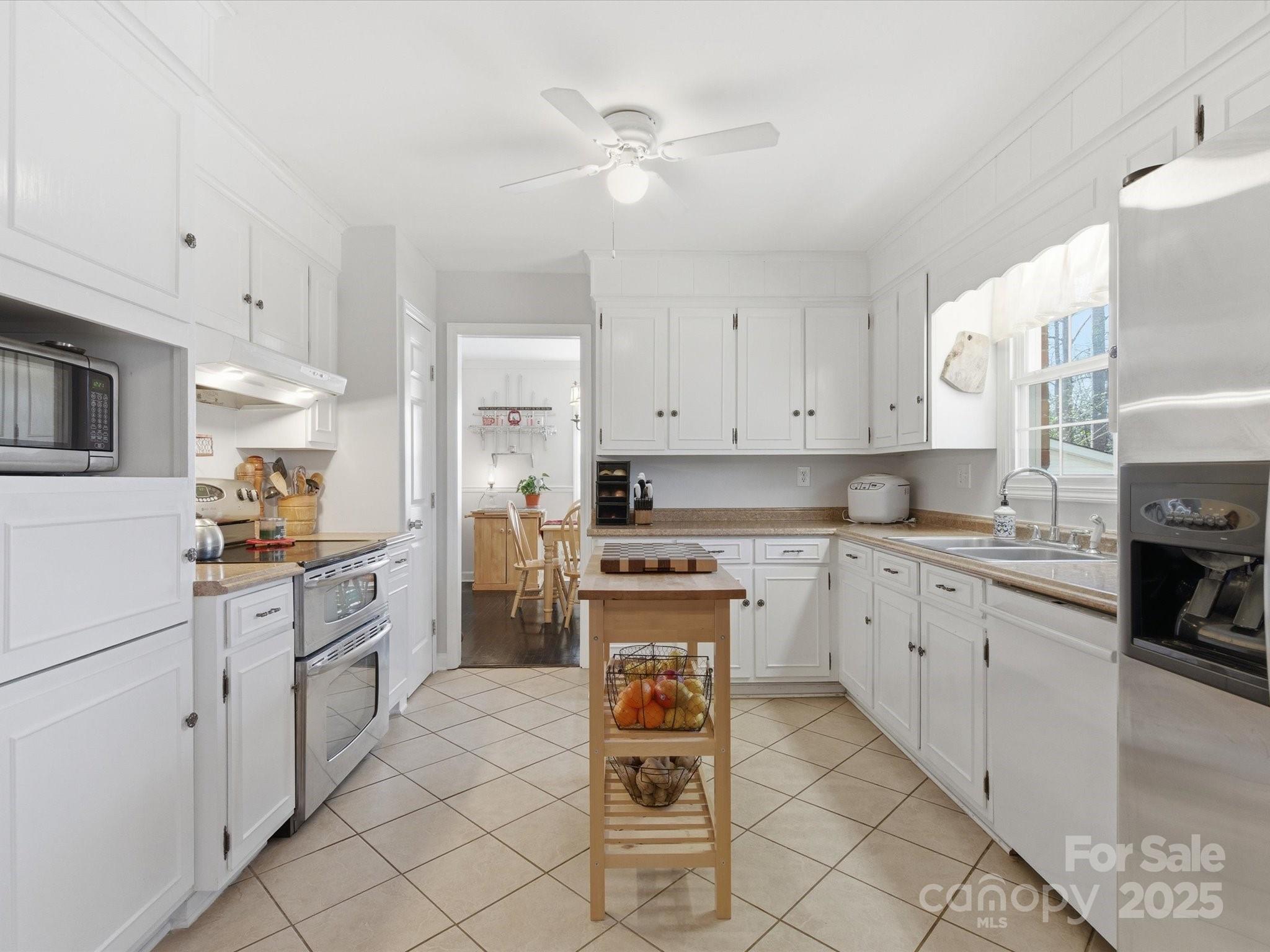 9941 Ferguson Road Charlotte, NC 28227 - Photo 17 of 29 a kitchen with white cabinets and appliances