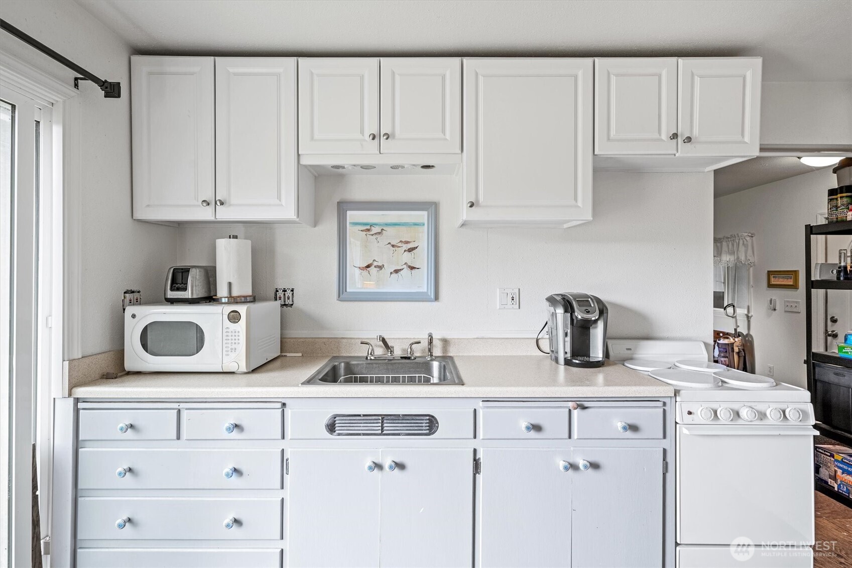 11303 Pacific Way Long Beach, WA 98631 - Photo 9 of 40 a kitchen with white cabinets and a sink