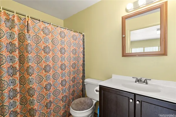 a bathroom with a granite countertop sink and a toilet
