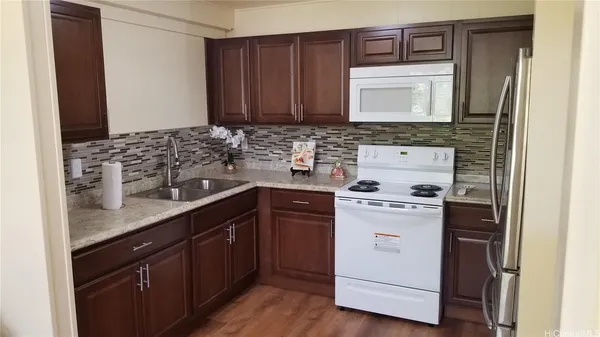 a kitchen with stainless steel appliances granite countertop a sink stove and microwave