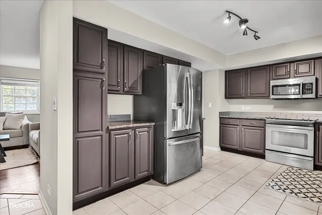 a kitchen with stainless steel appliances granite countertop a refrigerator stove and sink
