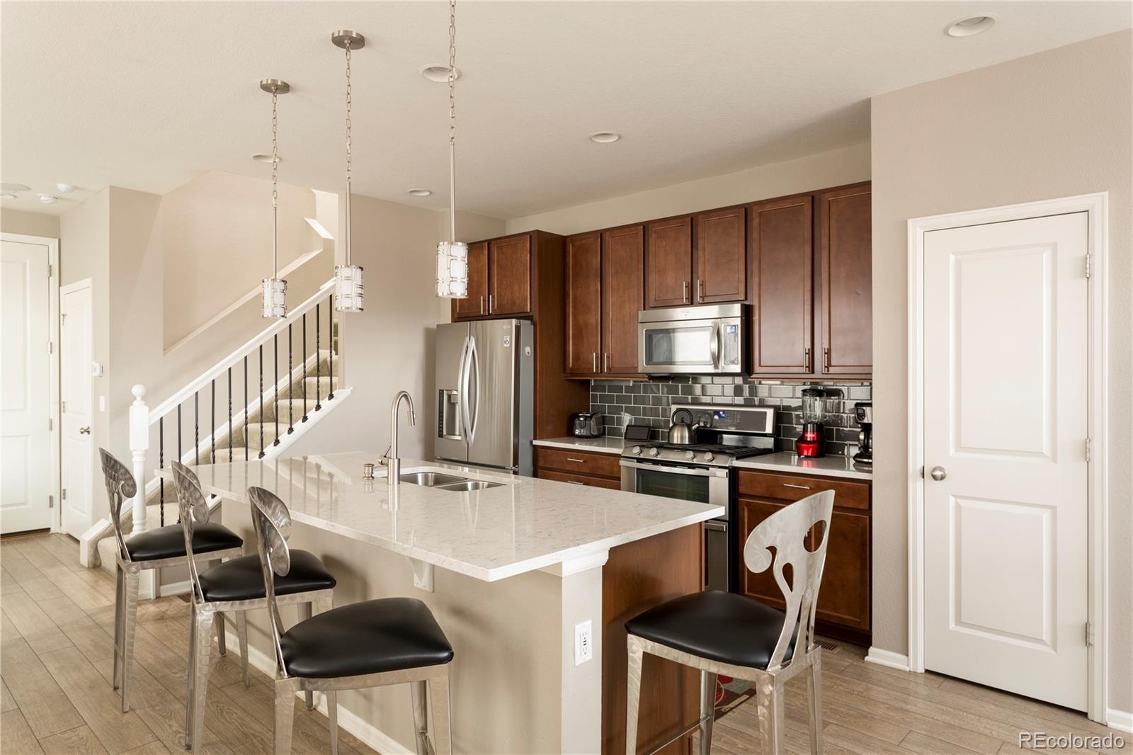 2834 Macon Way Denver, CO 80238 - Photo 7 of 36 a kitchen with stainless steel appliances granite countertop a stove a refrigerator and a dining table with granite countertops