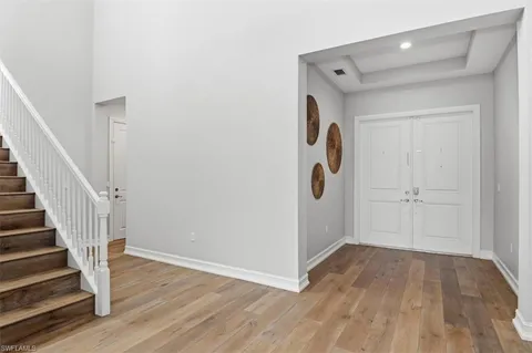 a view of a hallway with wooden floor and entryway