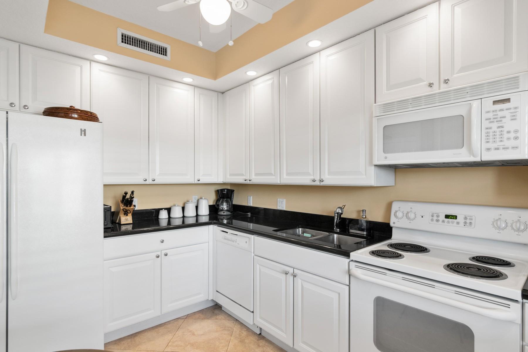275 South Beach Road, Unit C203 Jupiter, FL 33469 - Photo 9 of 21 a kitchen with white cabinets and white appliances